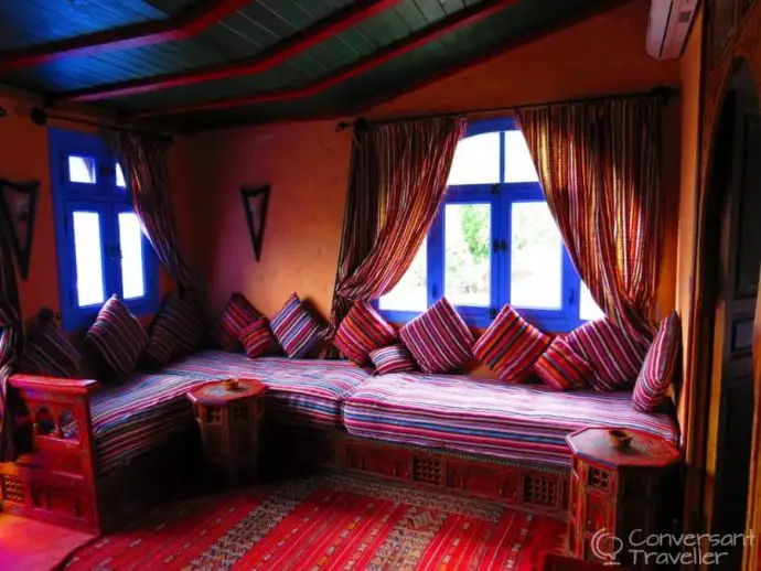 Inside a bedroom with colourful cushions and drapes