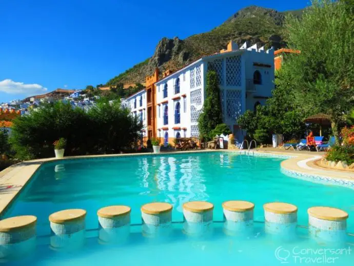 Swimming pool with stepping stones and hotel building behind