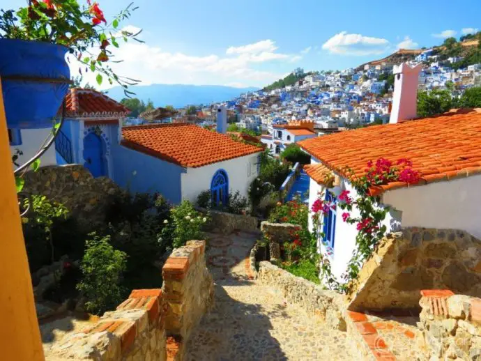 White bungalows with red tiled roofs overlooking a hillside city