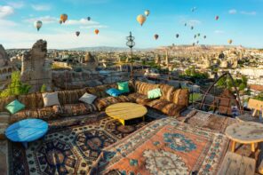 Terrace covered with rugs and hot air balloons in the distance