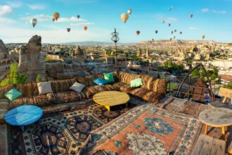 Terrace covered with rugs and hot air balloons in the distance