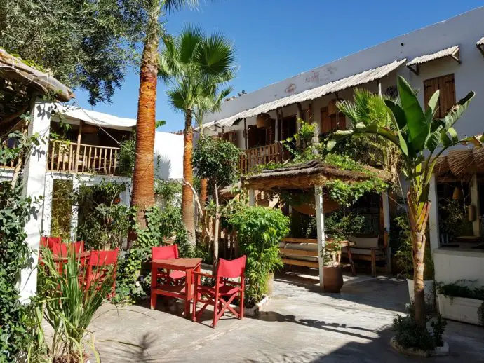 Red outdoor seating in a courtyard with palm trees