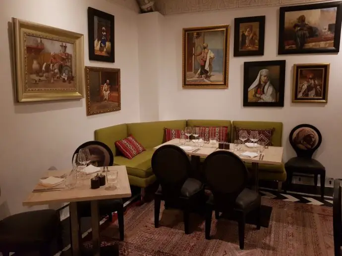 Restaurant dining room with tables and chairs, and photographs of people on the wall
