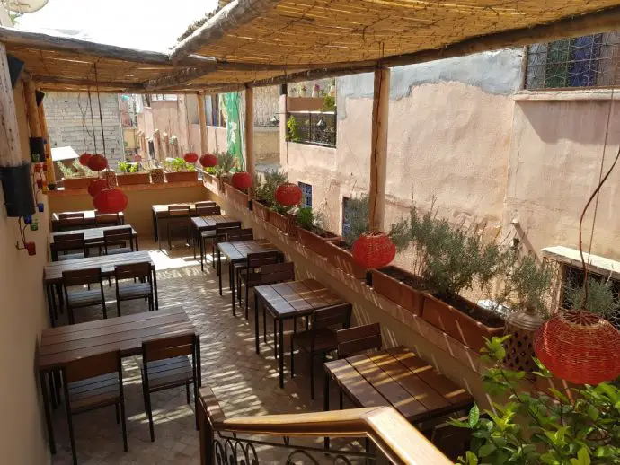 Roof terrace with table seating in a quiet alleyway of Marrakech