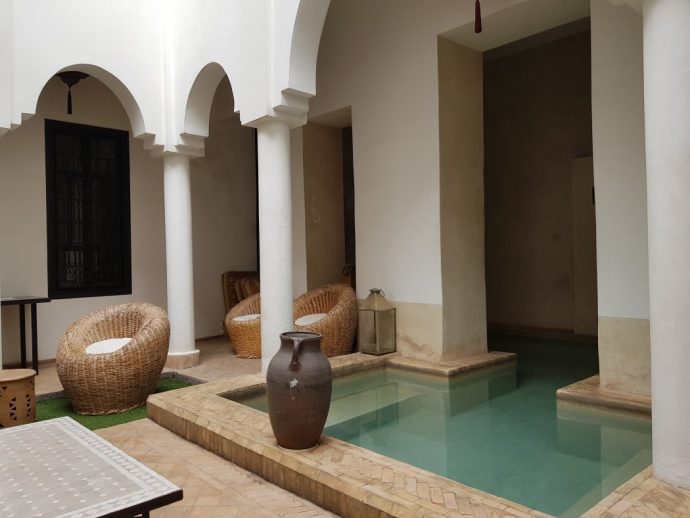 Dipping pool in courtyard of riad with wicker chairs beside it