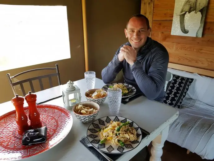 Eating dinner at the table in a glamping tent