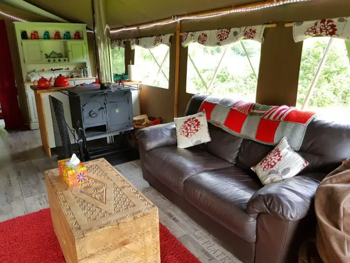 Sofa and kitchen area inside a glamping tent in Wales