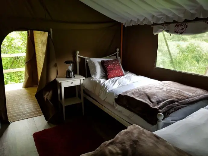 Twin beds with white sheets and red pillows