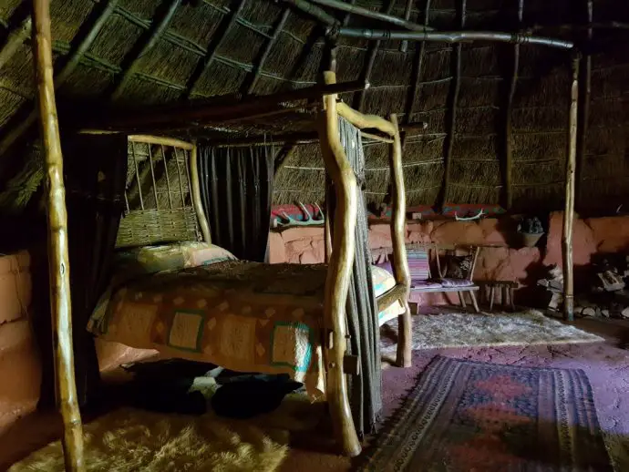 Wooden four poster bed inside a roundhouse - unusual places to stay in Cornwall