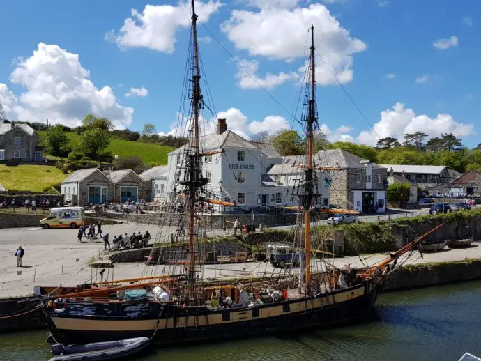 Pirate ship in a harbour with village buildings behind