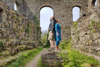 Ruined stone mine building with 2 people standing in the centre