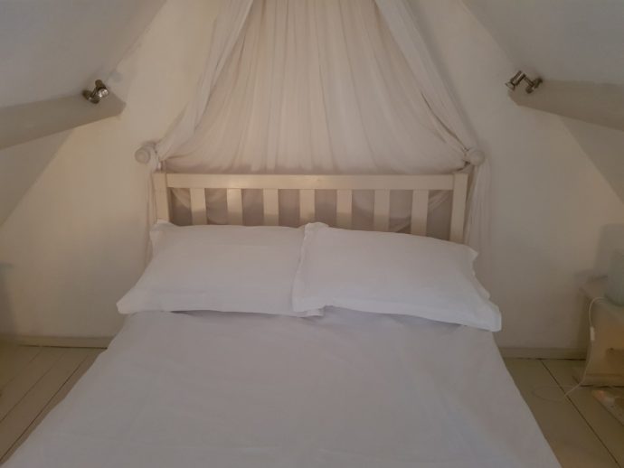 White bed with white walls and white covers