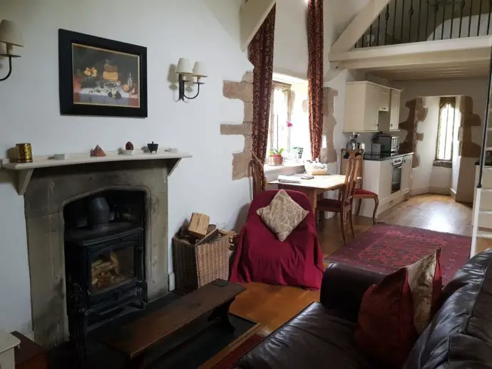 Inside a self catering gatehouse with fireplace, sofa and white walls