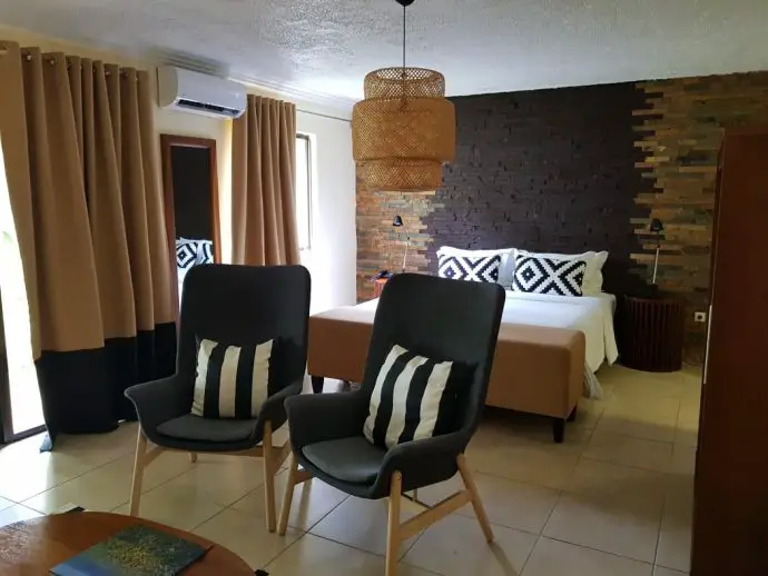 Bedroom with bed and two chairs, brown and yellow in theme