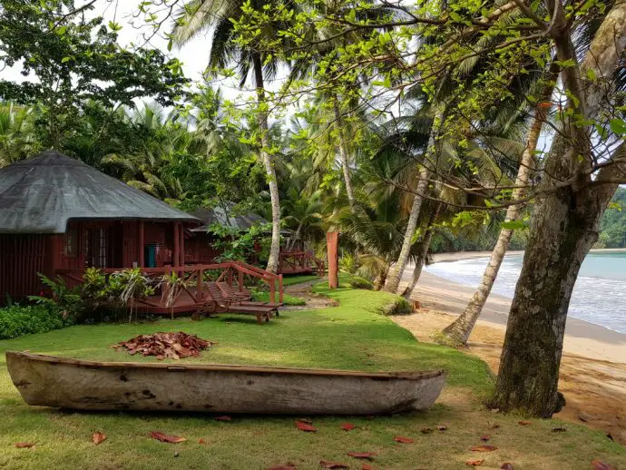 Beach bungalow just meters from the sea with palm trees and a wooden canoe - best beaches on Principe