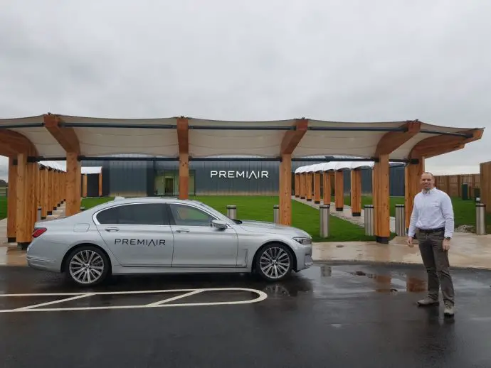 Man standing by car outside an airport terminal