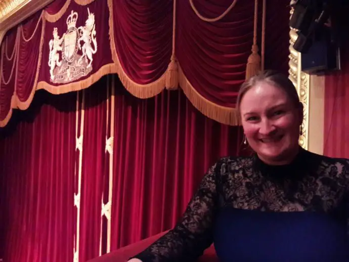 Woman standing in a box at the theatre