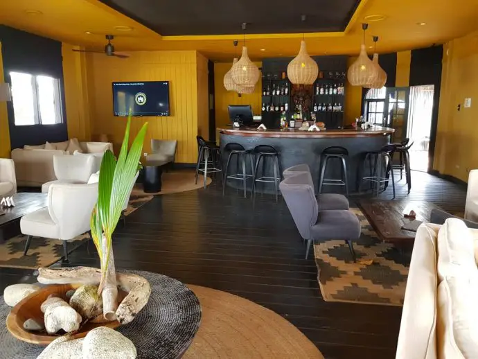 Bar room with yellow walls, rattan ceiling lights and comfy chairs