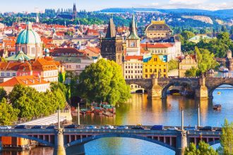 Aerial view of Prague with several bridges over a river and buildings either side