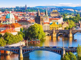 Aerial view of Prague with several bridges over a river and buildings either side