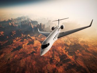 Private jet flying above mountain canyon