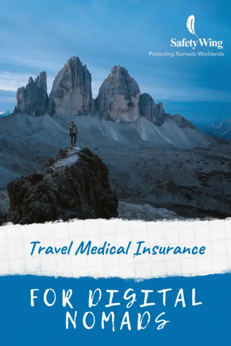 Travel insurance for digital nomads - man on mountain outcrop overlooking 3 distant peaks