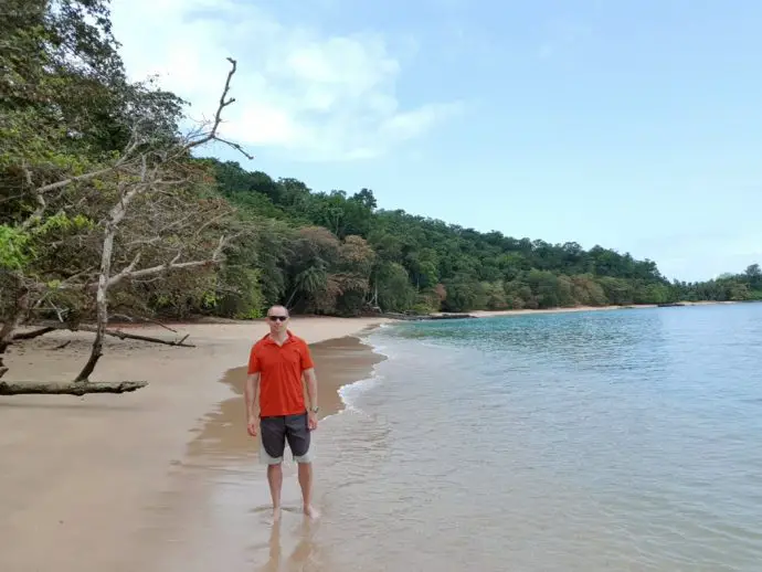 Beach with man in orange shirt, and sea on the right