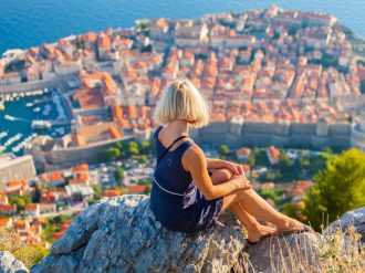Tourist on hill overlooking Dubrovnik city in Croatia