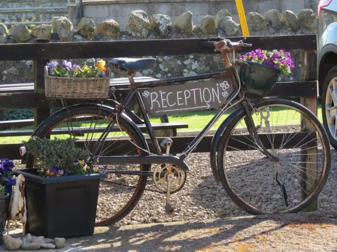 Old bicycle with a sign on it that says 'reception'