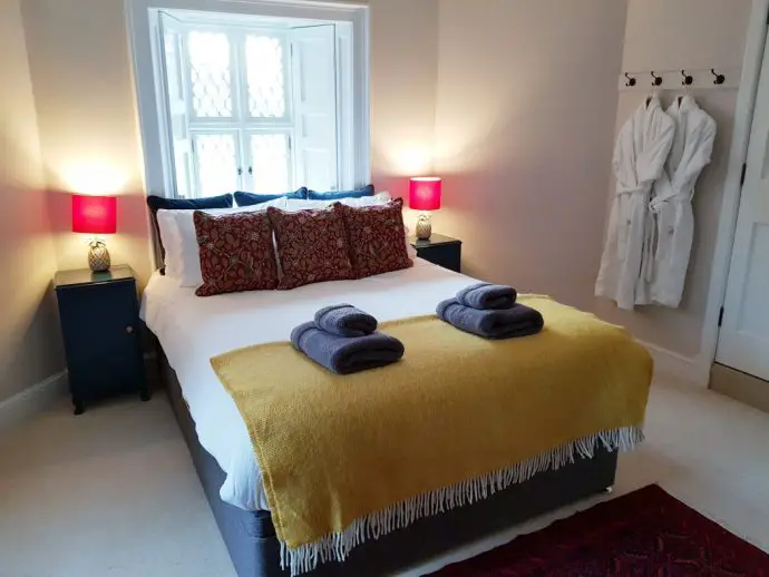 Bedroom with a double bed covered in a yellow blanket