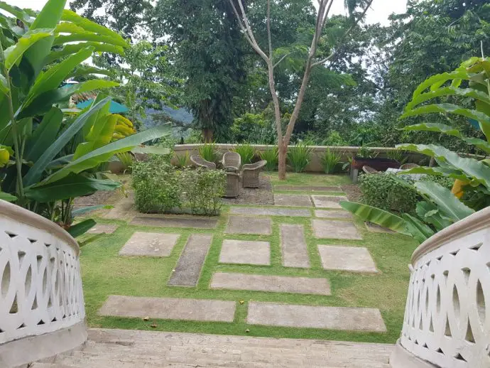 Garden terrace with stone steps leading down to lawned area - Review of a stay at Roça Sundy on Principe