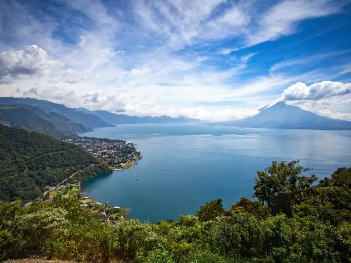 Blue lake surrounded by mountains covered in lush green forest