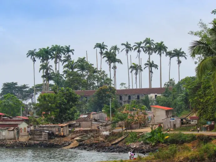 Rural village with wooden houses and palm trees beside the sea - one of the best places to visit on Sao Tome