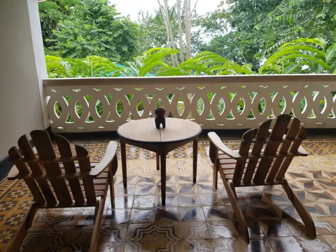 Balcony with 2 wooden chairs overlooking rainforest - Review of a stay at Roça Sundy on Principe