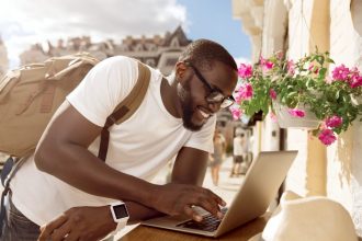 Digital Nomad - man working on laptop in European city - remote working