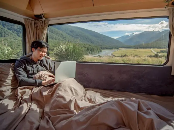 Digital Nomad - man working on laptop in campervan - remote working