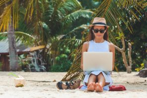 Digital Nomad - woman working with laptop on a beach - remote working