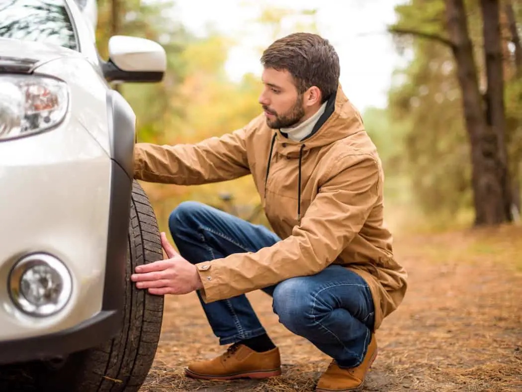 Checking tyres before a car road trip