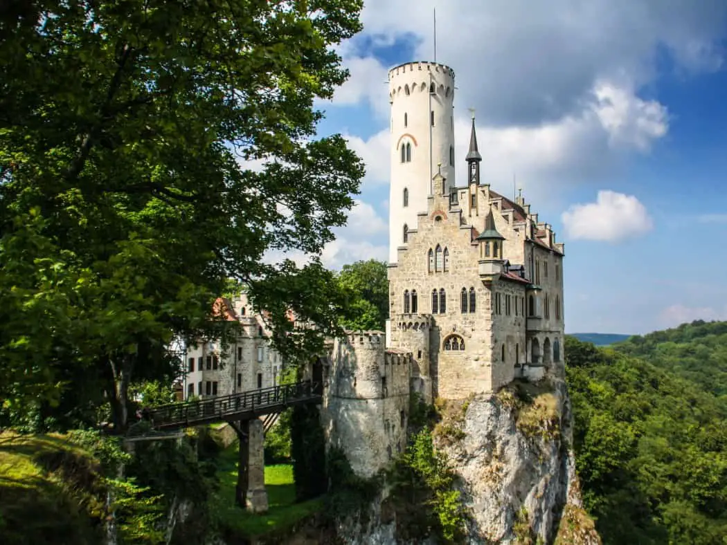 White castle on a rocky outcrop surrounded by trees