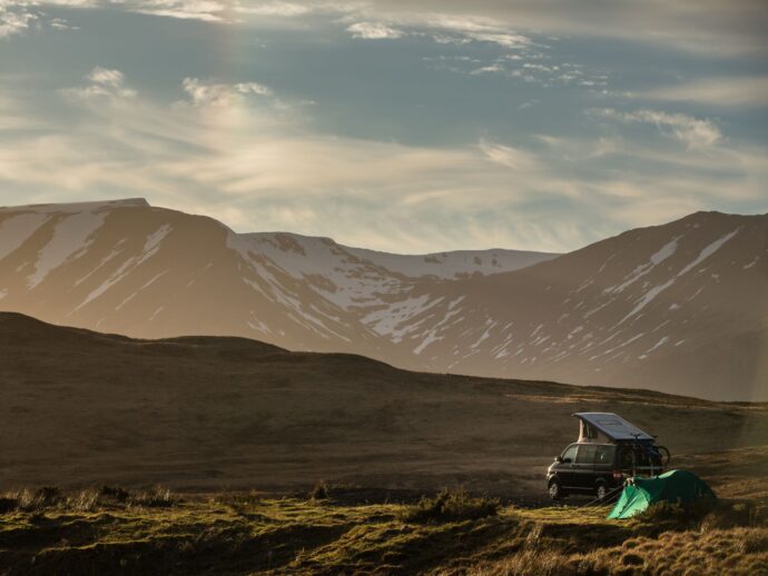 Campervan and tent in mountainous landscape