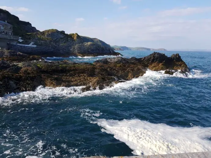Things to do in Mevagissey - waves crashing outside the harbour walls