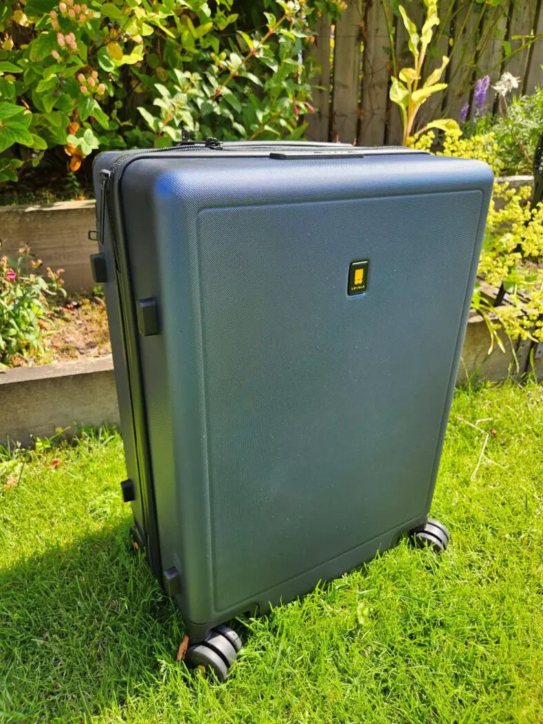 Level 8 Voyager Carry On Suitcase - blue suitcase standing on the grass