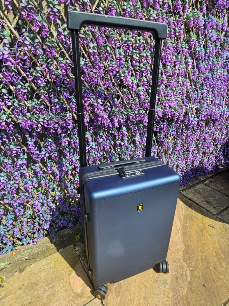 Blue suitcase with black handle extended.