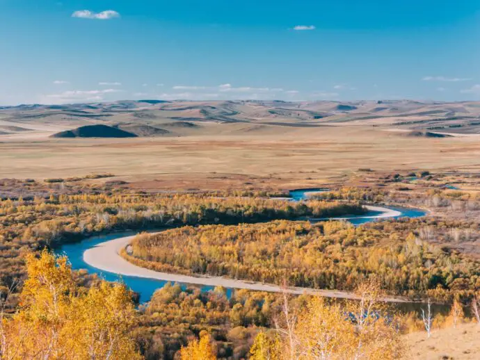 Grassland landscape with river running through it