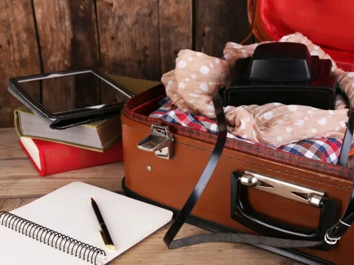 Brown suitcase being packed with clothes