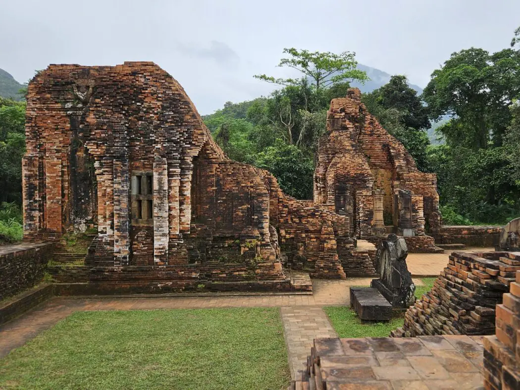 Red brick temple ruins surrounded by forest