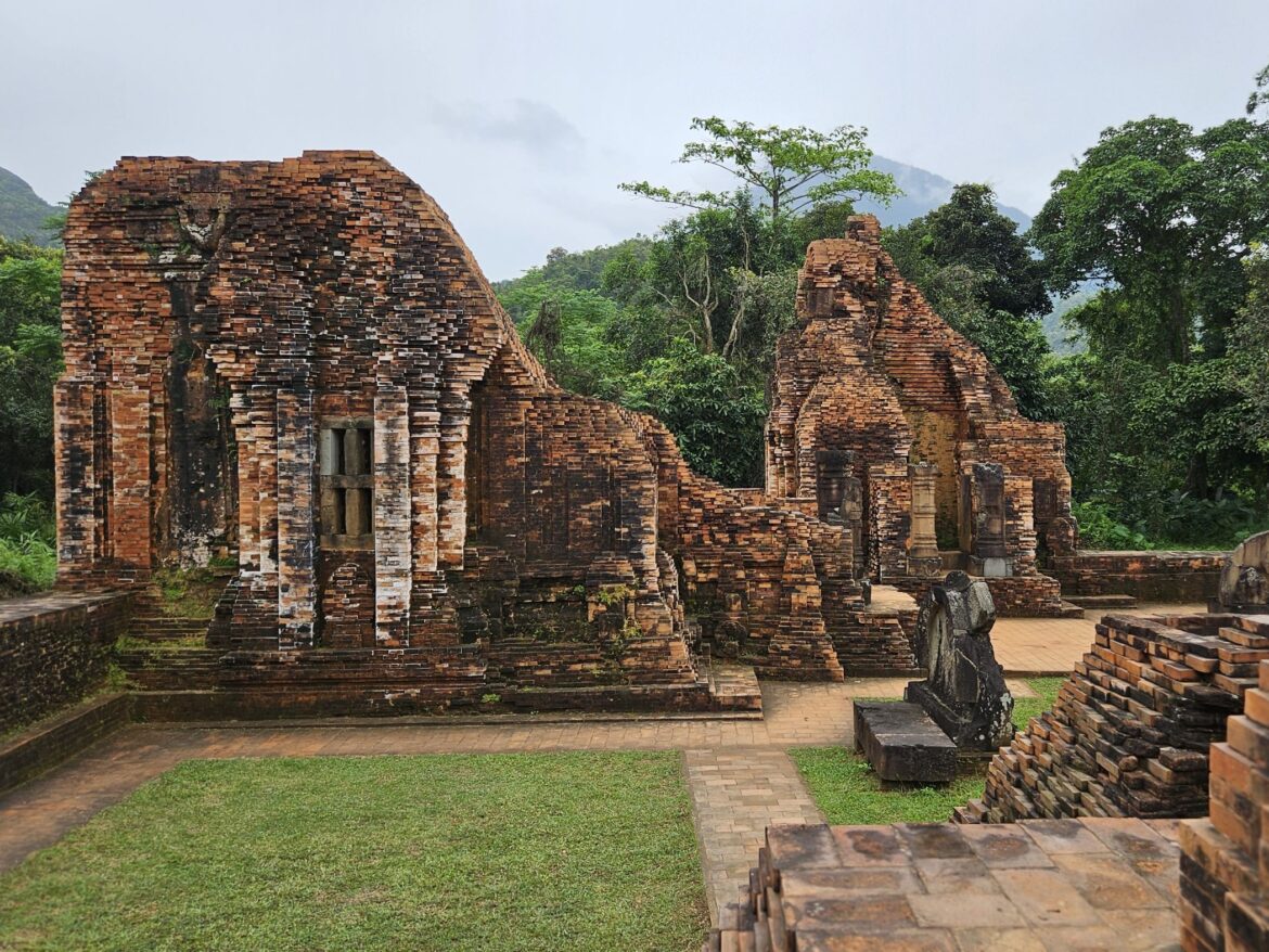 Red brick temple ruins surrounded by forest