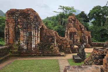 Red brick temple ruins surrounded by forest