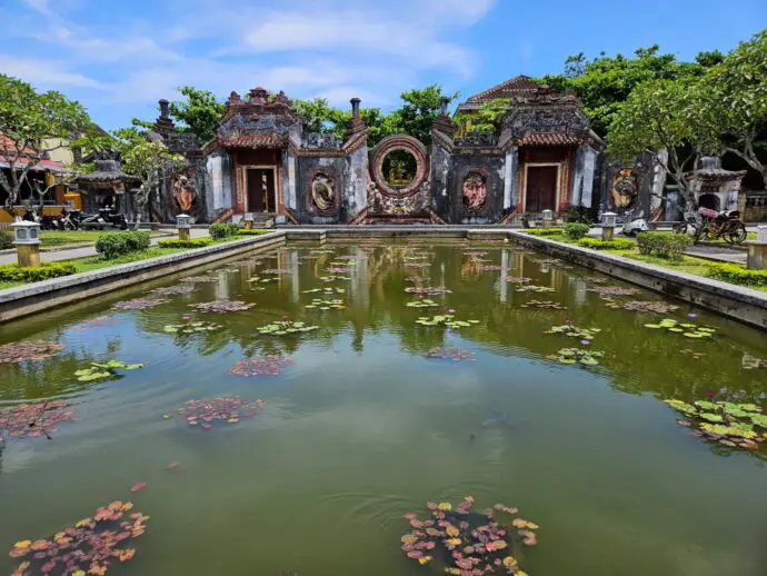 Ornate stone gate beside a lily pond