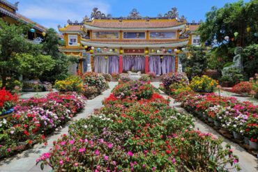 Temple with purple doors and flower beds in front